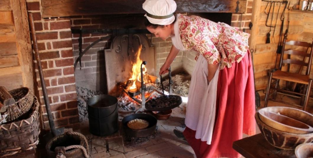 在约克镇的美国革命博物馆里，人们在壁炉上做饭。